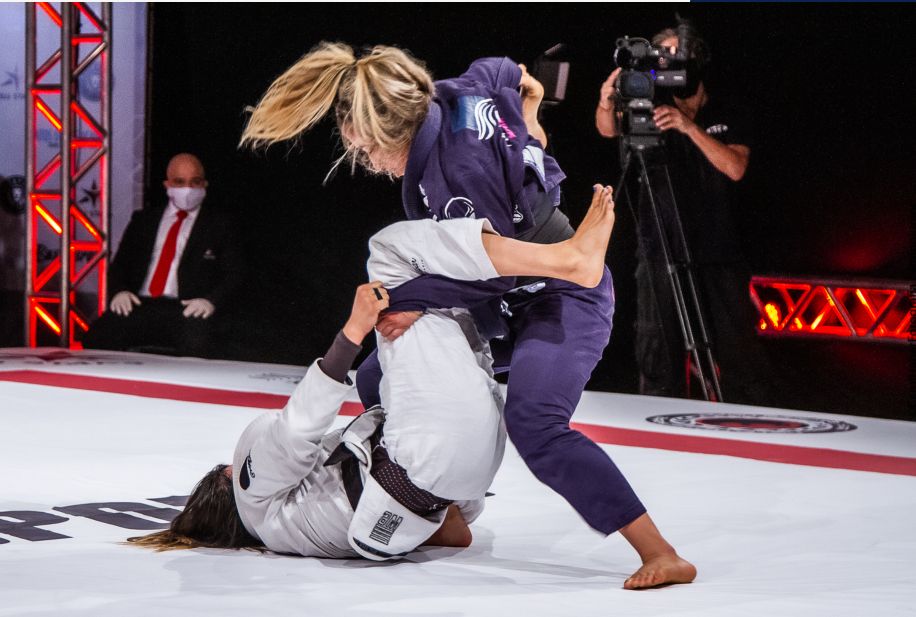 Atletas de kimono em luta no tatame iluminado do BJJ Stars